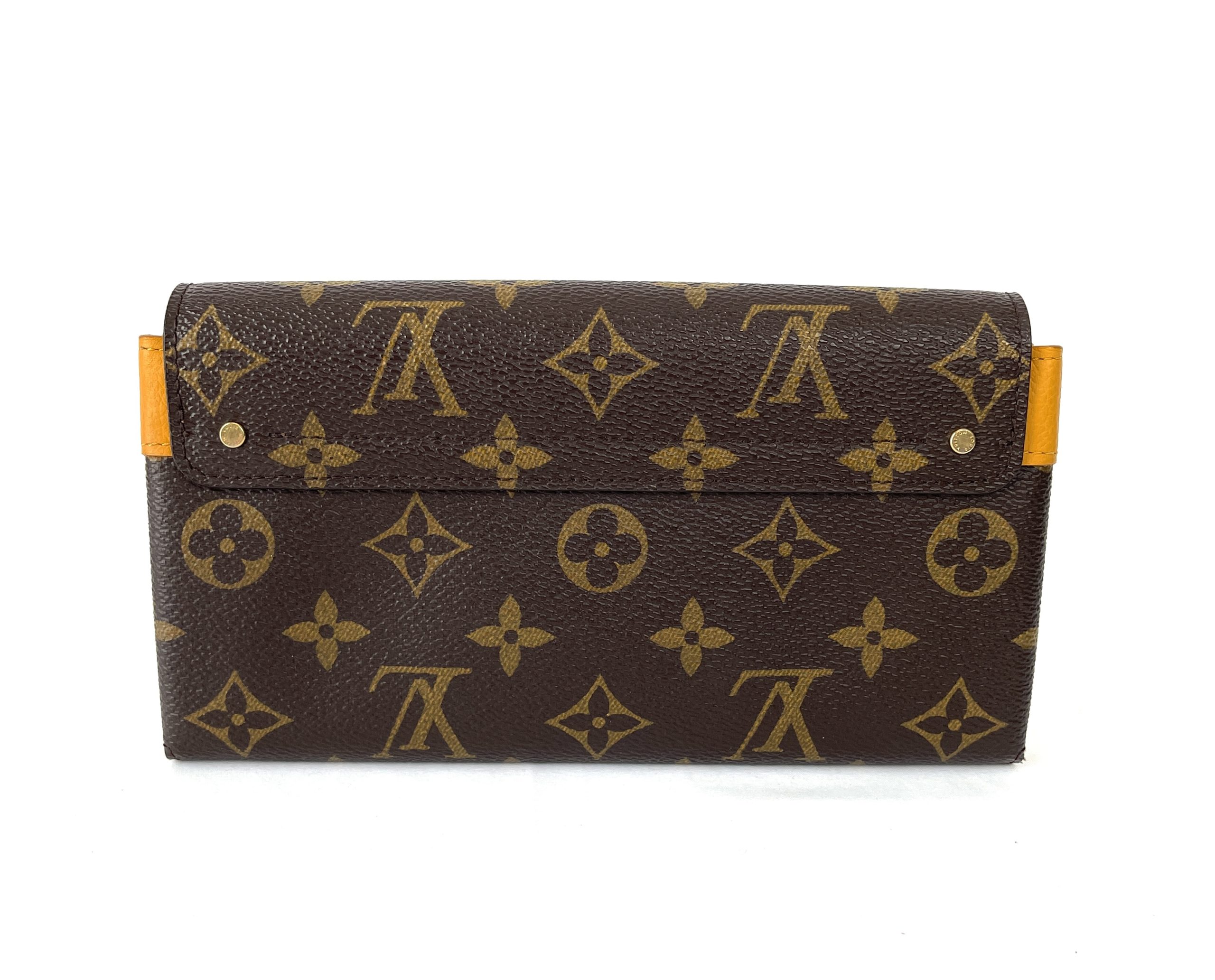 LOUIS VUITTON ELYSEE MONOGRAM WALLET, with gold tone clasp at the front and  red partitioned leather interior with a central zippered pocket and twelve  card slot panels, with dust bag, box and