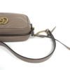 Angled view with the chain strap coiled beside the bag