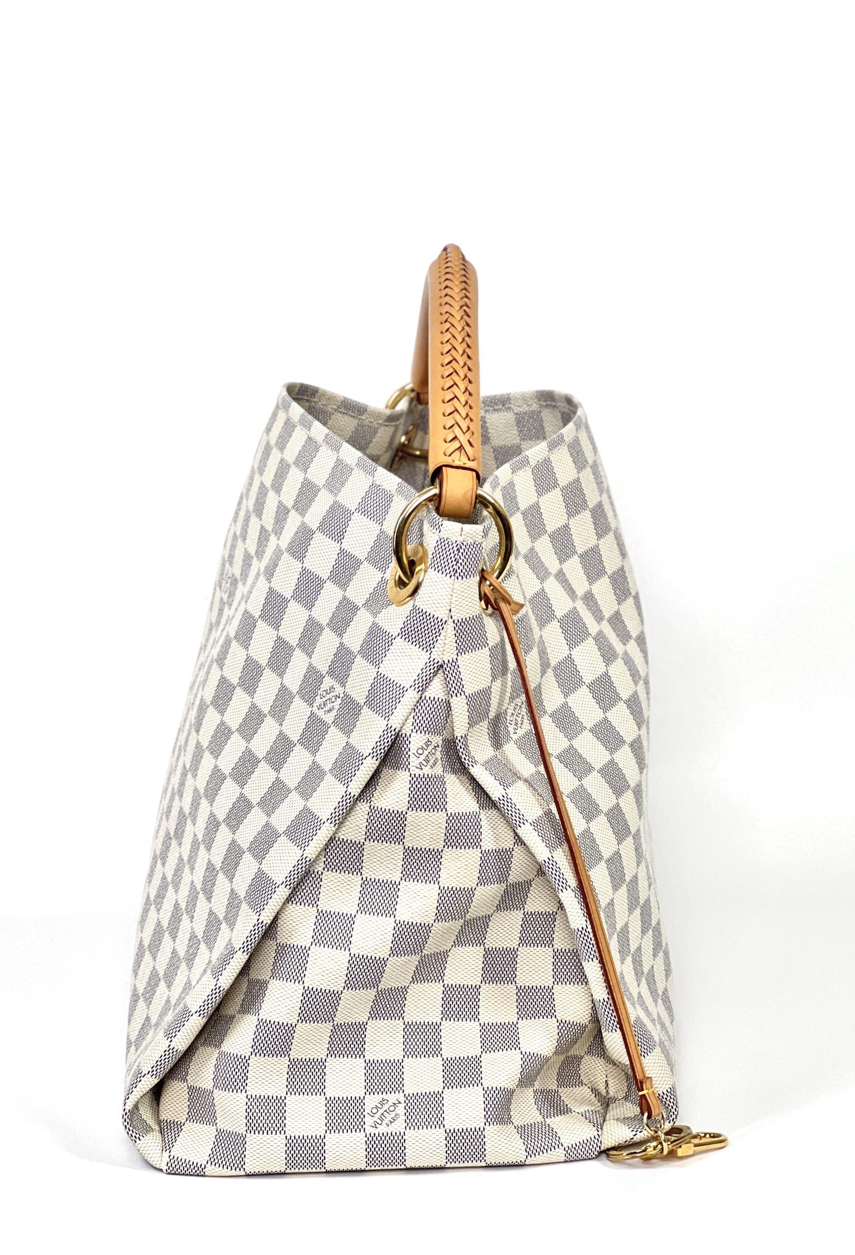 The Artsy MM features a damier azur canvas body, a rolled vachetta handle,  an open top, and interior zip and slip pockets.