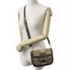the bag on a dress form with the leather strap