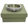 Bangle resting on its sage green presentation box