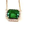 Close up of the emerald cut lab emerald in its diamond halo