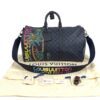 Duffle resting on its dust bag with the accessories laid out