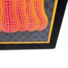 Corner of the lid showing the artwork and yellow border