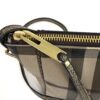Close up of the antique gold zip and leather pull