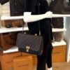 Mannequin holding the bag by its top handle
