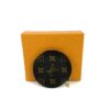 Coin purse leaning against its orange Louis Vuitton box