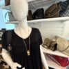 Necklace worn over a black dress on a mannequin