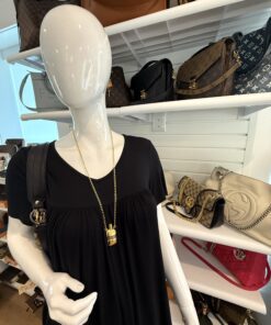 Necklace worn over a black dress on a mannequin