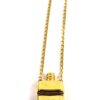 Close up of the gold perfume bottle pendant and its cap