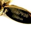 Oval tag reading M67930 held against the chain links