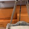 Close up of the light gold chain and its leather shoulder pad
