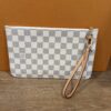 Pochette propped against the Louis Vuitton box with the strap