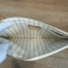 Interior opened by a gloved hand showing the striped lining