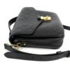 Angled view with the strap coiled beside the bag