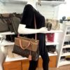 Mannequin holding the satchel at the side, front view