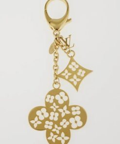 Louis Vuitton Ivy bag charm and keychain in gold tone metal with white enamel monogram flowers, shown hanging