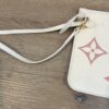 Pouch with the wristlet strap laid out beside it