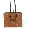 Angled view showing the caramel monogram side of the tote
