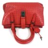 Top of the satchel with the handles folded over the closure