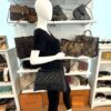 Model carrying the bag at the hip, front view in the boutique