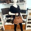 The tote held in hand by a mannequin