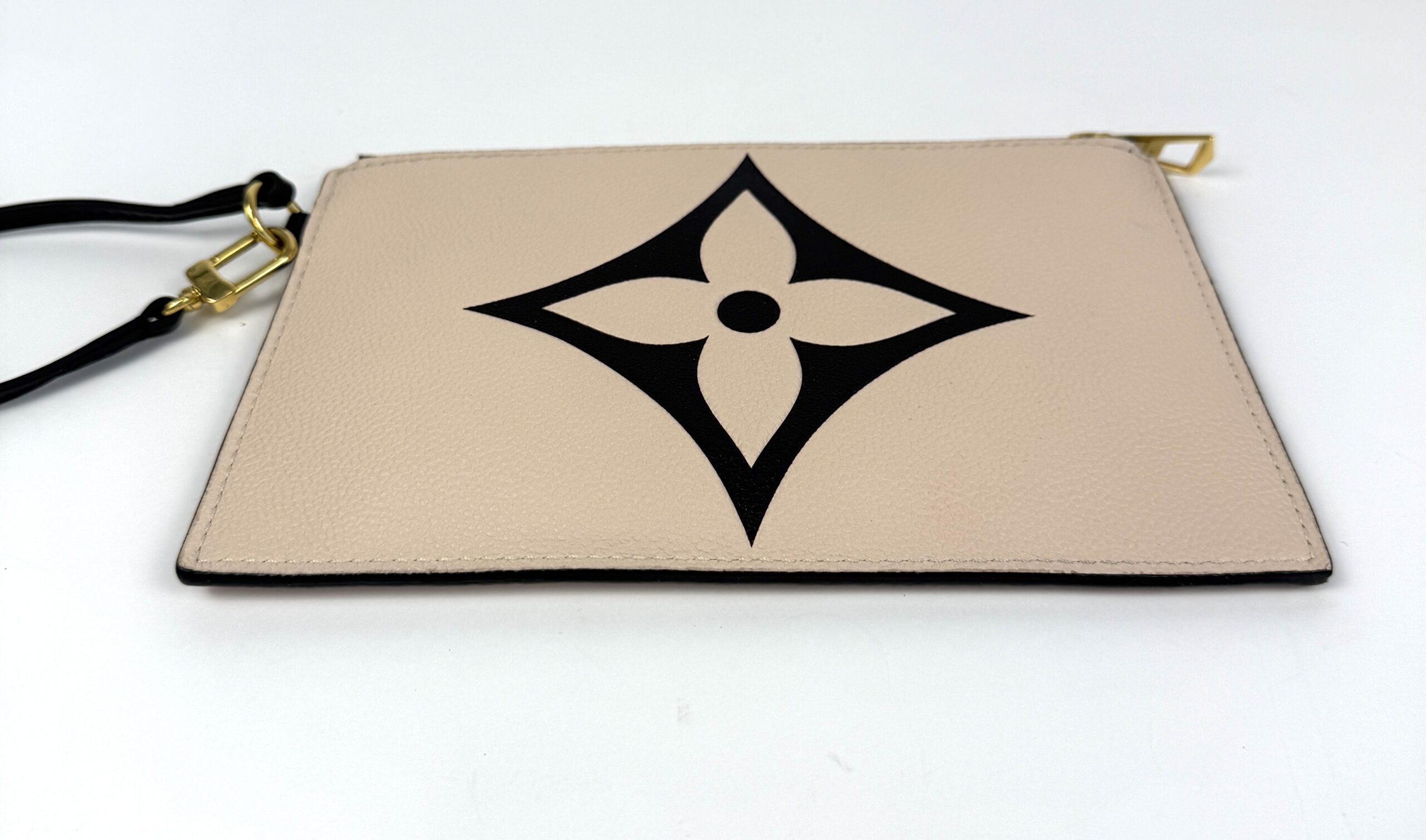 Pochette with its gold zip and wrist strap