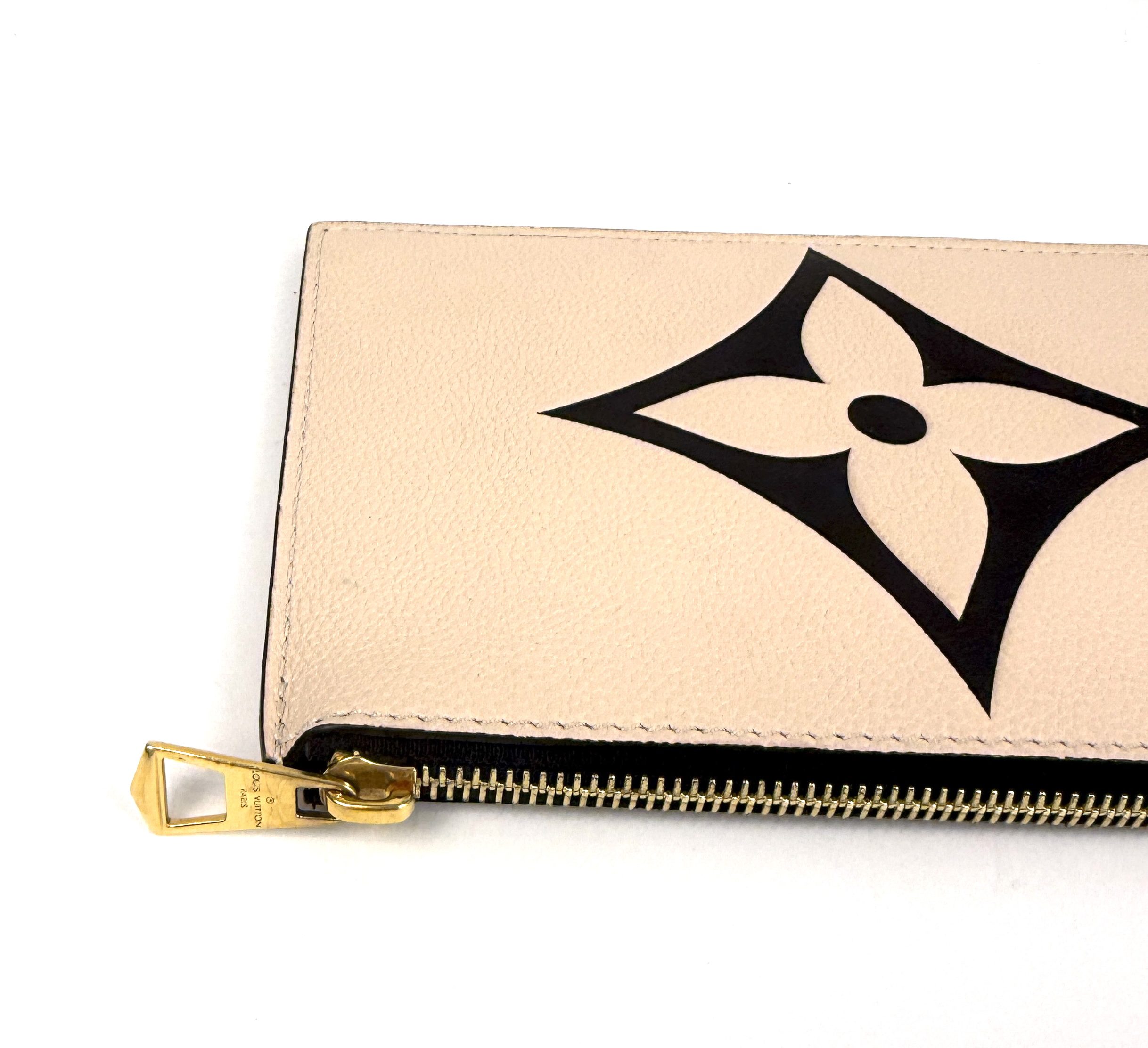 Close up of the embossed flower and gold zip pull