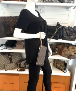 The pochette carried as a wristlet on a mannequin in the shop