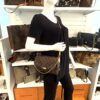 Styled on a mannequin, worn crossbody on the leather strap